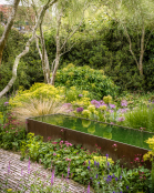 Corten steel trough in early June garden
